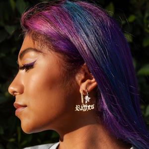 Model is wearing Equal Rights earrings, earrings are paved with words dangling, 22k gold plated & handmade in India. 